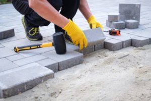 man installing pavers in patio