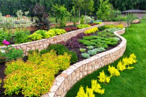Beautiful landscaping with luxury stone flowerbed in summer.